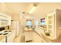 Eat-in kitchen boasts white appliances, island, and a view to the dining area at 2585 Karen Dr, Mount Dora, FL 32757