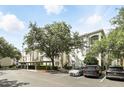 Condo exterior with ample parking and mature landscaping providing shade to the front of the building at 2639 Maitland Crossing Way # 102, Orlando, FL 32810