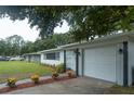 Exterior view of a single-story home showing the lawn, an attached garage, and a well-maintained flower bed at 2961 Northland Rd, Mount Dora, FL 32757