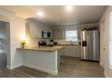 Bright kitchen featuring stainless steel appliances, granite counters, tile backsplash, and wood-look floors at 2961 Northland Rd, Mount Dora, FL 32757