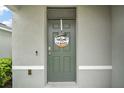 Close up front door with welcome wreath and neutral gray paint at 30422 Pintail Dr, Leesburg, FL 34748
