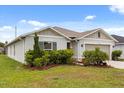 An inviting single-story home with a two-car garage and beautifully landscaped front yard at 3260 Casa Del Rey Ave, Kissimmee, FL 34746