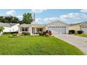 Inviting front yard with lush green lawn and attractive landscaping framing this charming single-story home at 3460 Idlewood Loop, The Villages, FL 32162