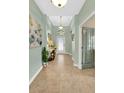 Inviting entryway featuring neutral tile flooring, decorative lighting, and a glass-paneled front door at 3604 Corsica Ln, Clermont, FL 34711