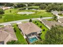 Aerial view of a home with a screened pool overlooking a lush green golf course and serene pond at 4210 Arlington Ridge Blvd, Leesburg, FL 34748
