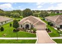 Inviting single-story home with lush landscaping, well-manicured lawn and a spacious driveway at 4210 Arlington Ridge Blvd, Leesburg, FL 34748