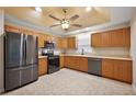 Spacious kitchen featuring stainless steel appliances, ample wood cabinetry, and tile flooring at 5071 Harbour Dr, Oxford, FL 34484