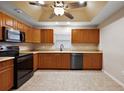 Well-equipped kitchen with stainless steel appliances, wooden cabinets, and a ceiling fan at 5071 Harbour Dr, Oxford, FL 34484