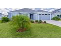 Charming single Gathering home boasts a well-manicured lawn, mature landscaping, and an attached two-car garage at 6949 Minchew Cir, The Villages, FL 34762
