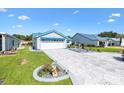 Attractive one-story home featuring a blue roof, attached garage, and well-maintained lawn at 714 Prado Dr, The Villages, FL 32159