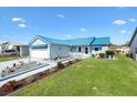 Cozy home with blue roof and awnings, showcasing landscaped front yard and spacious driveway at 714 Prado Dr, The Villages, FL 32159
