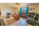 Comfortable living room with tile flooring, neutral walls, and natural light through a large window at 7211 Se 120Th St, Belleview, FL 34420