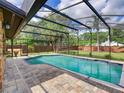 Inviting screened-in pool with brick patio, surrounded by lush landscaping and a privacy fence at 728 Silversmith Cir, Lake Mary, FL 32746