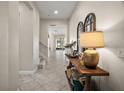 Spacious entryway with table, decorated with lamp and vases, and tiled floor at 9153 Carmela Ave, Davenport, FL 33897