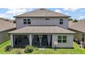 Rear exterior view of the home showcasing the screened patio and backyard at 9153 Carmela Ave, Davenport, FL 33897