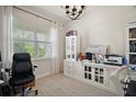 Well-lit office space features a large window with blinds and a custom cabinet with ample storage and bright neutral colors at 9153 Carmela Ave, Davenport, FL 33897