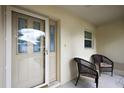Inviting front porch with seating area, featuring a storm door and glass accent door at 953 Mayo Ct, The Villages, FL 32162
