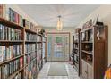 Welcoming entryway featuring built-in bookshelves with glass door and tiled floors at 1048 Cr 452A, Lake Panasoffkee, FL 33538