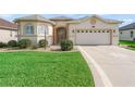 Inviting front exterior featuring a two-car garage, decorative driveway, and well-kept landscaping at 10927 Se 168Th Loop, Summerfield, FL 34491