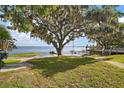 Expansive backyard leading to the lake, featuring a sandy area and dock at 13033 Se 158Th Ln, Weirsdale, FL 32195