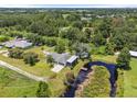 Expansive aerial view of the property showcasing a large backyard, pond, and surrounding lush greenery at 135 N James Pl, Groveland, FL 34736