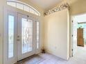 Bright entryway featuring tile floors, decorative glass door, and ornate floral wallpaper border at 13700 Se 90Th Ct, Summerfield, FL 34491