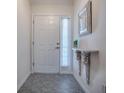 Bright entryway featuring tile flooring, a decorative shelf, and a classic white front door at 1419 Arbor Trl, The Villages, FL 32162