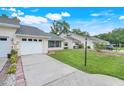 Inviting single-story home with well-manicured lawn, attached garage, and a neatly paved driveway at 1467 Disston Ave, Clermont, FL 34711