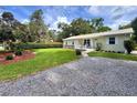 Well-maintained lawn leading to a charming single-story home with gravel driveway and landscaped front yard at 1537 Ne 22Nd St, Ocala, FL 34470
