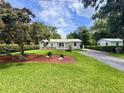Landscaped front yard with lush green lawn and mature trees surrounding a well-kept single-story home at 1537 Ne 22Nd St, Ocala, FL 34470