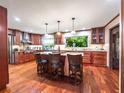 Gourmet kitchen boasting a center island with bar seating, custom cabinets, granite countertops and stainless steel appliances at 15733 Tower View Dr, Clermont, FL 34711