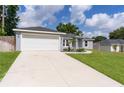 Well-maintained single-story home featuring a green lawn, and a convenient two-car garage at 15828 Se 98Th Ter, Summerfield, FL 34491