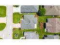 A bird's-eye view of a well-maintained home with lush green landscaping and a brick-paved driveway at 16730 Se 78Th Lillywood Ct, The Villages, FL 32162
