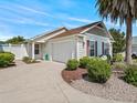 A single-story home with a well-manicured lawn and a driveway leading to an attached garage at 1762 Meadowlark Ave, The Villages, FL 32162