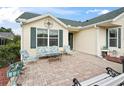 Charming front patio area featuring brick pavers, comfortable seating, and a quaint, cozy atmosphere at 17860 Se 89Th Natchez Ave, The Villages, FL 32162