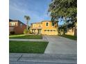 Charming two-story home featuring a bright yellow exterior, well-kept lawn, and a spacious driveway at 2122 Waseca Ln, Leesburg, FL 34748