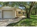 Close up front exterior featuring a well-maintained lawn and mature trees at 2708 Lorraine Dr, Leesburg, FL 34748