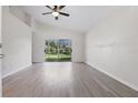 Bright living room with vaulted ceilings, wood-look floors, and sliding glass doors to a backyard view at 2708 Lorraine Dr, Leesburg, FL 34748