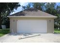 Exterior view of a two car detached garage with a white door at 31104 Fairvista Dr, Tavares, FL 32778