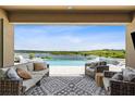 Inviting outdoor seating area with a view of the pool, spa, and serene lake at 3304 Canna Lily Pl, Clermont, FL 34711