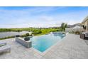 Gorgeous infinity pool and spa overlooking a picturesque lake with an adjacent golf course at 3304 Canna Lily Pl, Clermont, FL 34711