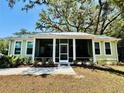 Inviting home with a screened porch and landscaped yard, creating a perfect spot for relaxation at 3607 Umbrella Tree Ln, Oxford, FL 34484