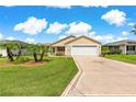 Inviting single-story home with a manicured lawn, palm trees, and a two-car garage at 362 Arbella Loop, The Villages, FL 32162