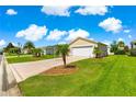 Attractive home featuring a well-maintained lawn, palm trees, and a two-car garage at 362 Arbella Loop, The Villages, FL 32162