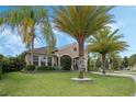 Inviting home exterior showing a lush green lawn and manicured landscaping with beautiful palm trees at 4018 Chandler Estates Dr, Apopka, FL 32712