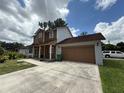 Exterior view of home showing two-car garage and long driveway at 402 E Maple St, Winter Garden, FL 34787
