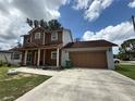 Charming two-story home with a covered front porch and attached two-car garage with a brown door at 402 E Maple St, Winter Garden, FL 34787