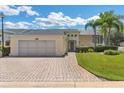 Beautifully landscaped home boasts a brick driveway, a spacious two-car garage, and a well-manicured lawn at 425 Glen Arbor Ln, Leesburg, FL 34748