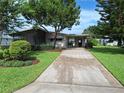 Charming single-story home with a long driveway, mature trees and a screened in porch at 432 Santa Fe E Rd, Tavares, FL 32778