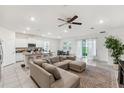Bright, open-concept living room, kitchen and dining area featuring tile floors and a modern ceiling fan at 4701 Nw 51St Terrace Rd, Ocala, FL 34482